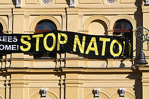 Banner with slogans “Yankees go home!” and “Stop NATO!”