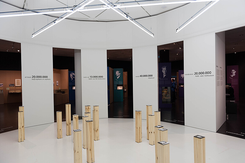 Wooden steles In the second exhibition space, numbers of war dead and biographies in the background